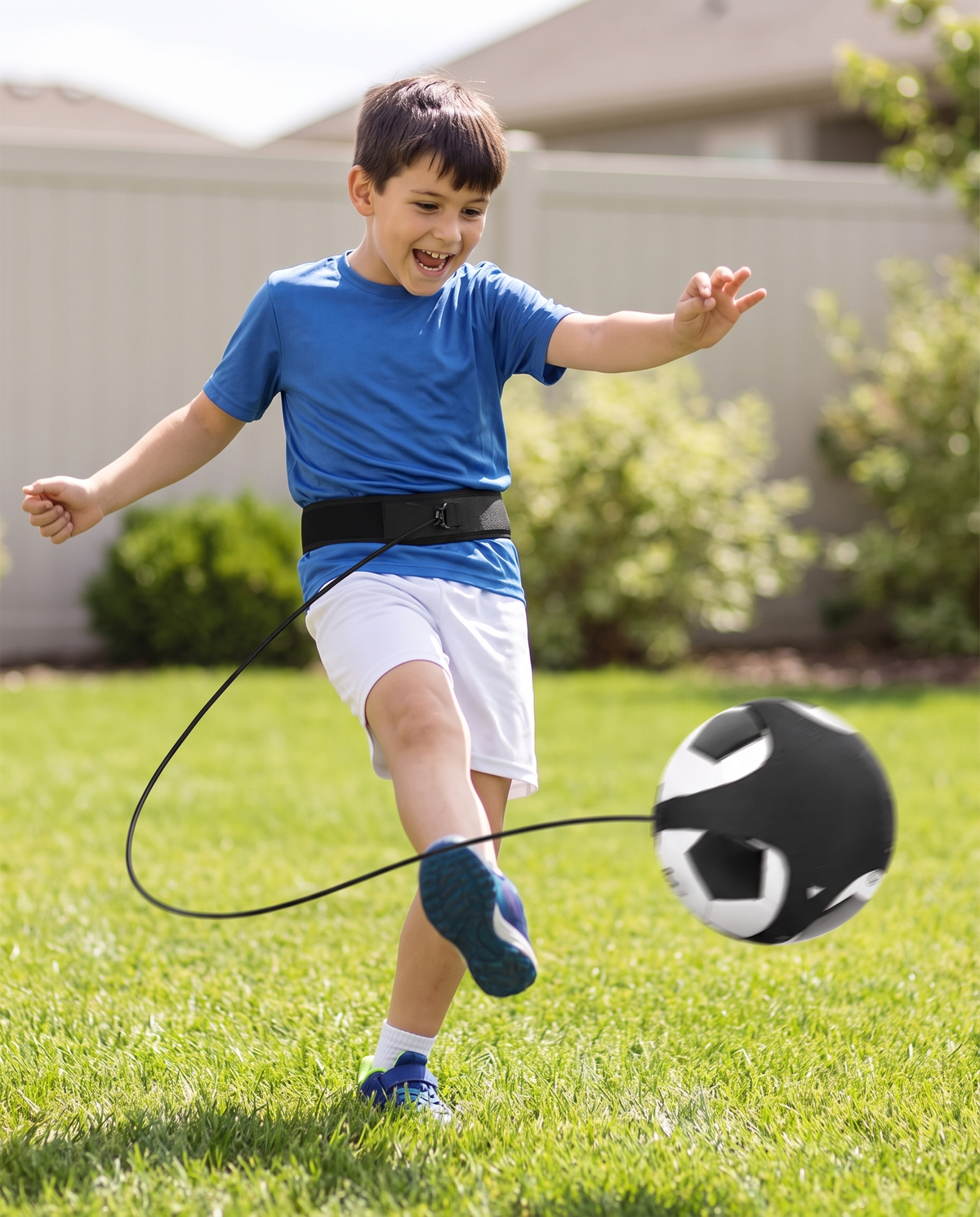 Niño practicando fútbol solo con el entrenador de tiro Blinda Kick Trainer Pro en el patio de casa